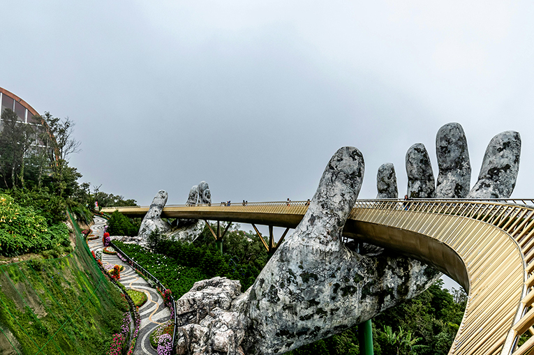 Au cœur du Vietnam, on peut découvrir le “pont doré” ou “pont d’or” - Cau Vang en vietnamien. Ce pont à la balustrade scintillante de 150 m de long est comme suspendu par deux mains géantes en béton. 
[©https://www.pexels.com/]