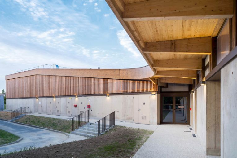 Pour la nouvelle salle multi-sports du complexe sportif de Sainte-Eulalie, Cemex a livré Vertua, un béton de terre qui affiche une réduction d’environ 150 kg CO2/m3. [©Blamm Architecture]